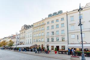 a group of people walking on a street in front of a building at Warsaw Story - LoftAffair Collection in Warsaw