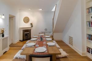 a dining room with a long table and a fireplace at Cosy Family Home Near Thorpe Park & Legoland in Old Windsor