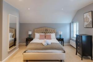 - une chambre avec un grand lit, 2 tables et une commode dans l'établissement Cosy Family Home Near Thorpe Park & Legoland, à Old Windsor