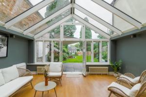 um jardim de Inverno com um tecto de vidro e uma sala de estar em Cosy Family Home Near Thorpe Park & Legoland em Old Windsor