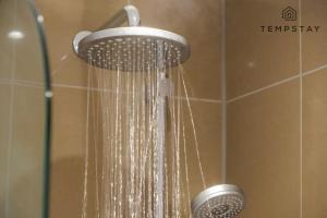 a shower with a shower head in a bathroom at Cosy Family Home Near Thorpe Park & Legoland in Old Windsor +15 photos