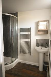 a bathroom with a shower and a sink at Sweet Pea Cabin in Badsey