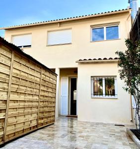 una valla de madera frente a una casa en Maison de ville tout confort à Cannes et à 10 Minutes à pied de la plage en Cannes