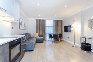 伦敦Cleveland Residences Farringdon的配有沙发和桌子的厨房和客厅