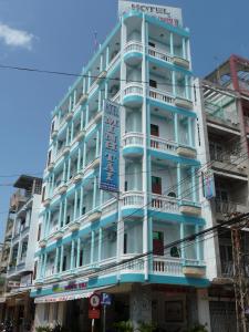 un edificio azul y blanco con un cartel en él en Minh Tai Hotel en My Tho