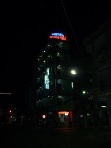 a tall building with a neon sign on it at night at Minh Tai Hotel in Mỹ Tho