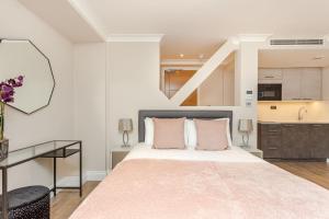 a bedroom with a large bed and a desk at Cleveland Residences Farringdon in London