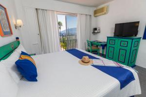 a bedroom with a bed with a hat on it at Hotel Victoria Oaxaca in Oaxaca City