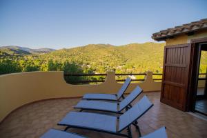 a group of chairs sitting on a patio with mountains in the background at Cann'e Sisa Luxury Villa Perla Marina B in Torre delle Stelle