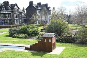 a small house sitting in the grass in front of a house at Brathay Lodge in Ambleside