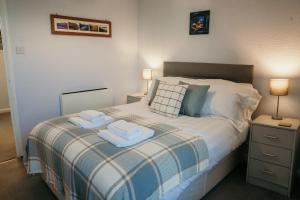a bedroom with a bed with two towels on it at 14 Burnett House by Prestige Properties SA in Seascale