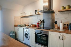 a kitchen with a stove and a washing machine at 14 Burnett House by Prestige Properties SA in Seascale