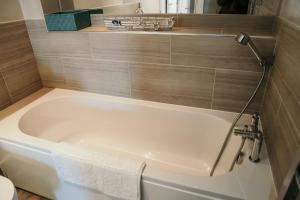 a white bath tub in a bathroom with a mirror at 14 Burnett House by Prestige Properties SA in Seascale
