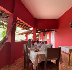 a dining room with a table and red walls at Vila das Estrelas - Guesthouse in Lençóis