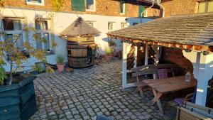 einen Pavillon mit einem Tisch und einer Bank im Innenhof in der Unterkunft Spreewald Spreemilia Gurkenbude in Lübbenau