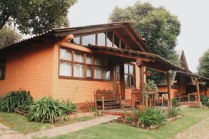 a small wooden house with windows and a porch at La Huerta in Mazamitla
