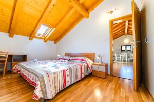een slaapkamer met een bed en een houten vloer bij Apartman Marina in Martinšćica