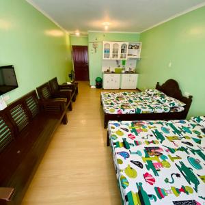 Cette chambre comprend 2 lits et des chaises. dans l'établissement Albergo Hotel - Studio Condo Unit - Baguio Transient, à Baguio