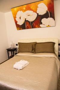 a bedroom with a bed with a painting on the wall at Little House in Modugno