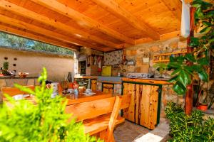 an outdoor kitchen with a table and a wooden ceiling at Apartman Marina in Martinšćica
