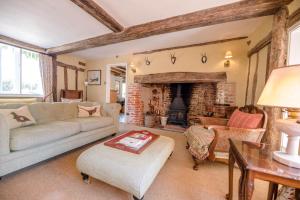 a living room with a couch and a fireplace at Bridge House in Kersey in Ipswich