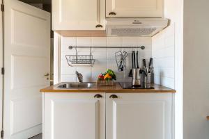 a kitchen with white cabinets and a sink at Casa Gracia Apartments in Barcelona