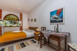 a bedroom with a bed and a desk and a table at Guesthouse Casa Nova in Poreč