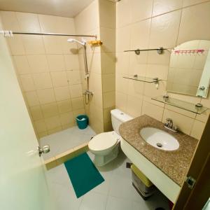 La salle de bains est pourvue d'un lavabo, de toilettes et d'une douche. dans l'établissement Albergo Hotel - Studio Condo Unit - Baguio Transient, à Baguio
