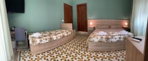 una camera con due letti e una televisione di Erythrà Bed and Breakfast a Reggio di Calabria