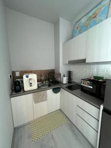 a small kitchen with white cabinets and a sink at JY HOME -Jesselton Quay Citipads Mt Kinabalu View and Seaview, Contactless Self Check-in, Free WiFi in Kota Kinabalu