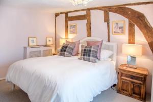 a bedroom with a white bed with pillows at Rose Cottage in Lavenham in Lavenham