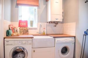 a kitchen with a washing machine and a sink at Rose Cottage in Lavenham in Lavenham