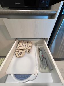 a drawer in an appliance with knives and scissors at JY HOME -Jesselton Quay Citipads Mt Kinabalu View and Seaview, Contactless Self Check-in, Free WiFi in Kota Kinabalu