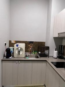 a kitchen counter with a sink and a microwave at JY HOME -Jesselton Quay Citipads Mt Kinabalu View and Seaview, Contactless Self Check-in, Free WiFi in Kota Kinabalu