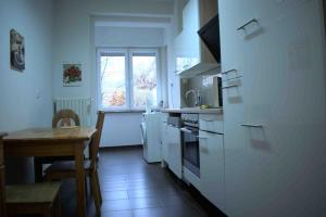 a kitchen with white appliances and a table and a window at Goldstadt Ferienwohnung in Pforzheim