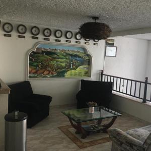 uma sala de estar com uma mesa e um quadro na parede em Hotel San Nicolas em Bucaramanga