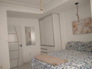 Dormitorio pequeño con cama y armario en APARTAMENTO TEMPORADA EM PORTO SEGURO, en Porto Seguro