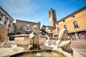Una statua di leone seduta sopra una fontana di Domus Solarii Holiday Home a Bergamo