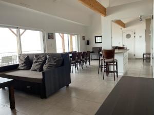 een woonkamer met een bank en een tafel en stoelen bij Résidence Belle Plage in La Tranche-sur-Mer