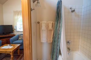 a bathroom with a tub and a shower with towels at The Swan Hotel in Port Townsend