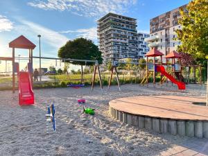 um parque infantil com escorregas e um baloiço na areia em British Quarter Apartments em Praga