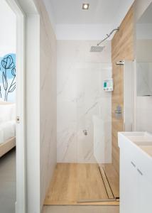 a white bathroom with a shower and a sink at Rosalina Ocean Park in San Juan