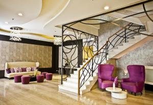 een lobby met paarse stoelen en een trap bij The Exchange Regency Residence Hotel Managed by HII in Manilla