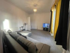 a living room with a couch and a tv at 3 Bedroom Entire Flat, Luxury facilities with Affordable price, Self Checkin/out in Fife