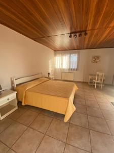um quarto com uma cama e um tecto de madeira em Hostaria delle Memorie em Curinga