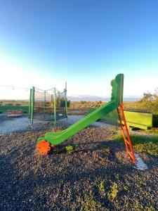 un toboggan verdoyant dans un parc avec une aire de jeux dans l'établissement Hostaria delle Memorie, à Curinga