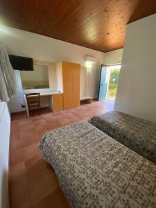 um quarto com 2 camas, uma mesa e uma secretária em Hostaria delle Memorie em Curinga