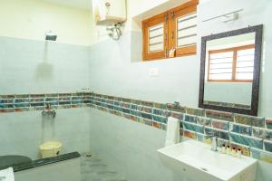 a bathroom with a sink and a mirror at The Inglewood Bungalow in Yercaud