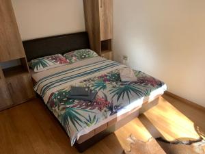 ein Schlafzimmer mit einem Bett mit einer tropischen Tagesdecke in der Unterkunft Apartman LUX STELLA in Zlatibor