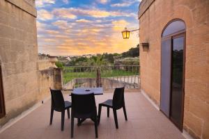 a table and chairs on a patio with a view at Centre Island Holiday Home with private pool and hot tub in Kerċem